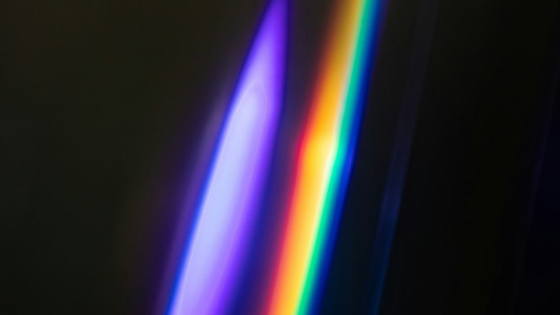 Faisceau de lumière coloré sur fond sombre, dégradé du violet au rouge